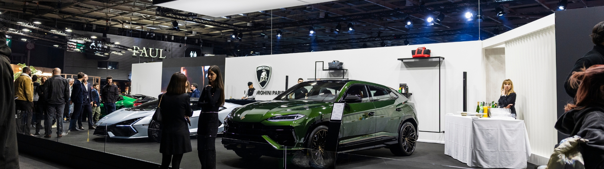 Photo grand angle d’un exposant où des supercars sont présentées comme des œuvres d’art, dans une atmosphère immersive et exclusive.