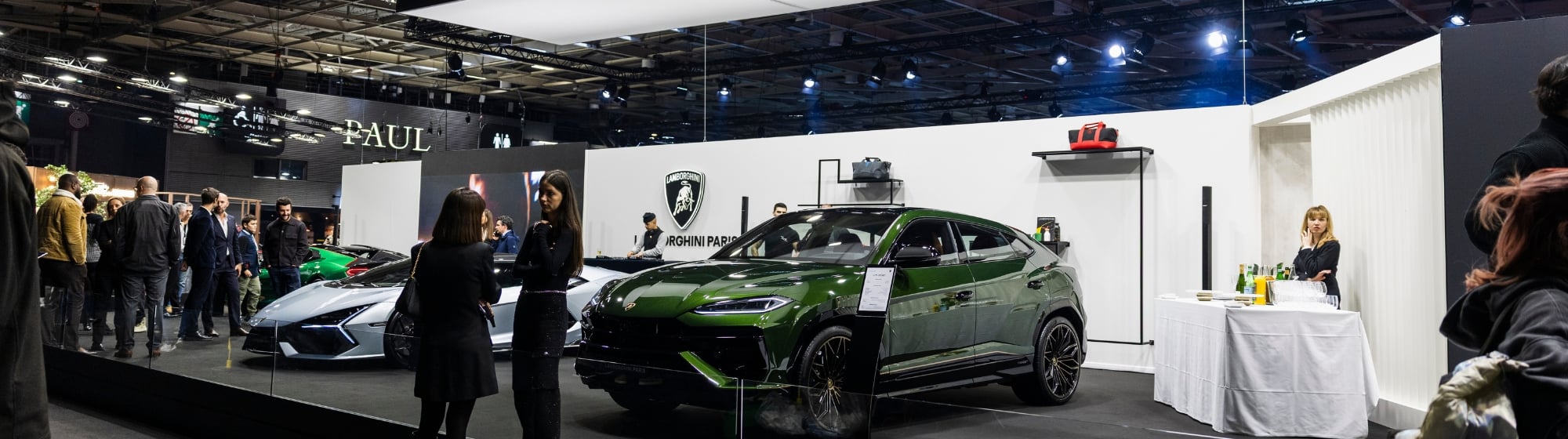 Wide-angle photo of a dramatic exhibition hall where anonymous supercars are displayed like artworks, in an immersive and exclusive atmosphere.