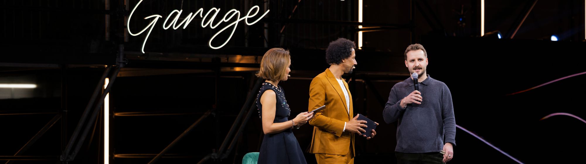 Journalist on the neon-lit live stage talking to a designer