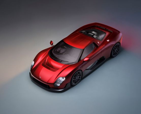 Red McLaren McL 6GT supercar displayed in a studio three-quarter view