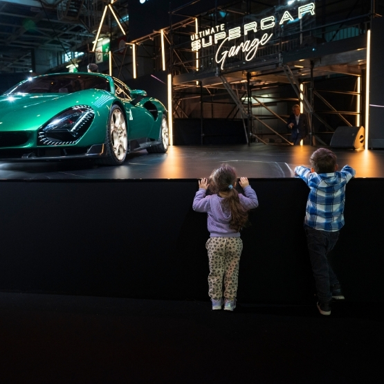 Un enfant et un adolescent regardant une super car 