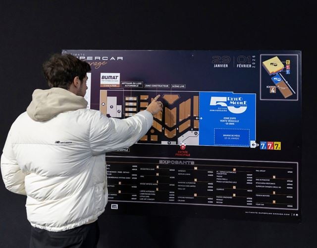 Visiteur consultant le plan de visite interactif d’Ultimate Supercar Garage