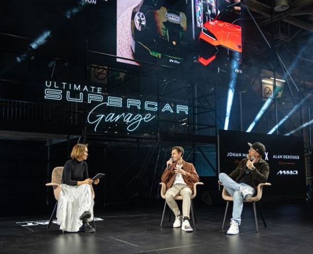 Three speakers discussing automotive topics on the Ultimate Supercar Garage stage.