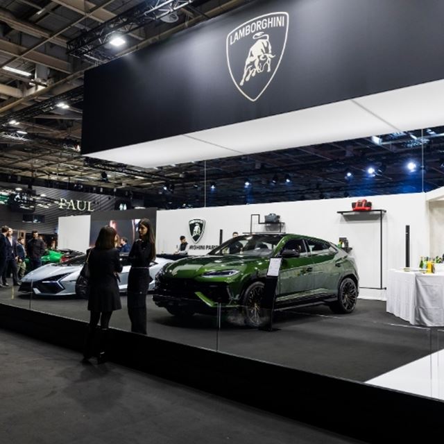 Photo of supercar exhibitors at a show, cheerfully exchanging about their reasons for exhibitin