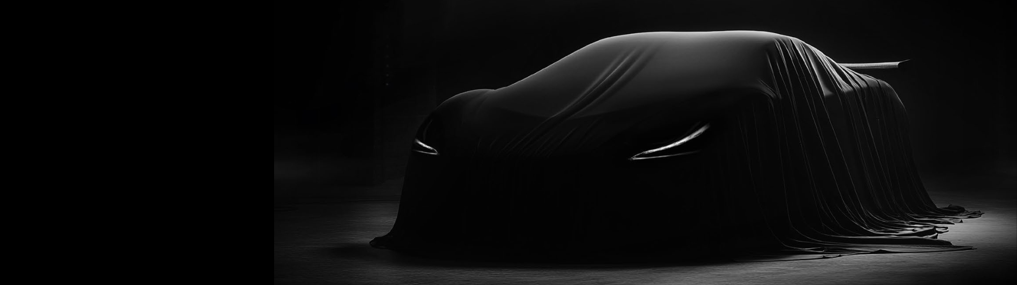 Black supercar covered with a tarp.