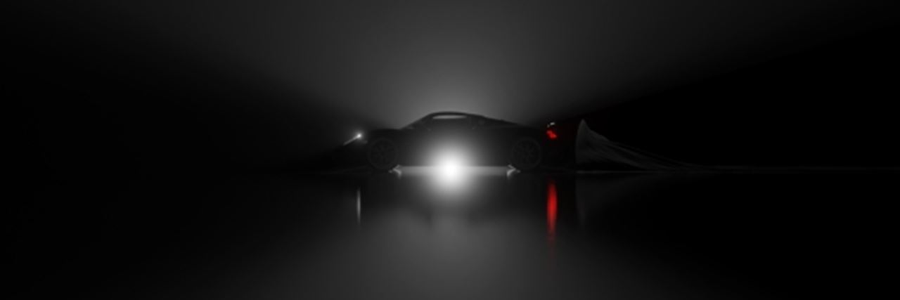 Supercar seen from the side with a black background and a spotlight